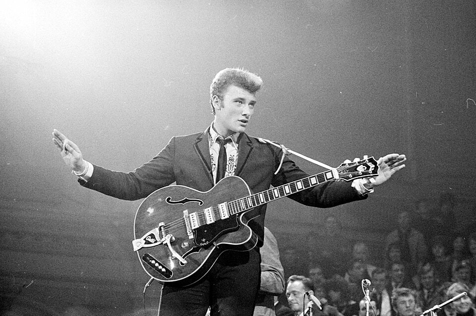 Johnny Hallyday playing guitar on stage when he was young